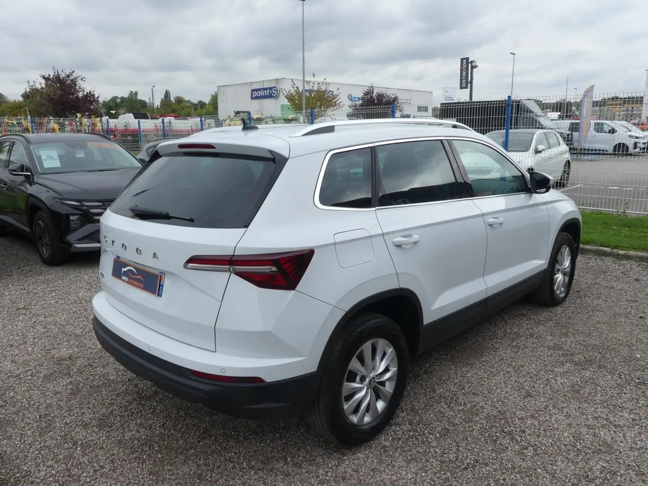 SUV SKODA KAROQ blanc vu de trois quarts arrière droit avec vitres teintées et jantes alliage 17 pouces