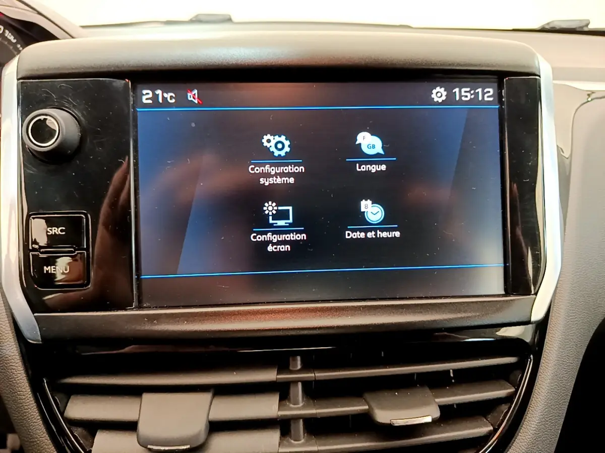 Écran tactile central affichant les réglages du système dans l'habitacle d'une Peugeot 208 Puretech blanche de 2019.