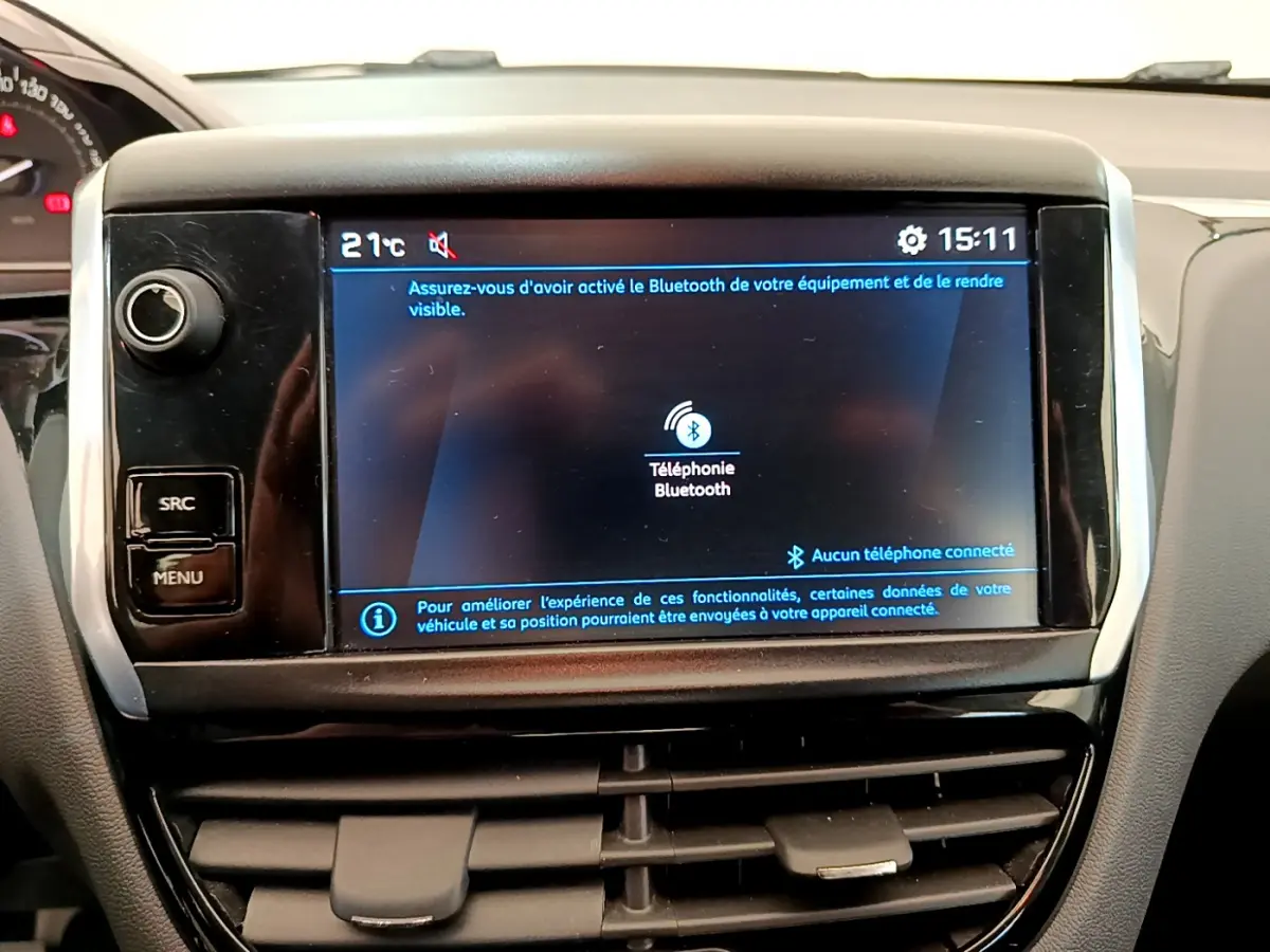 Écran tactile central affichant la connexion Bluetooth dans l’habitacle d’une Peugeot 208 blanche, vue de face.