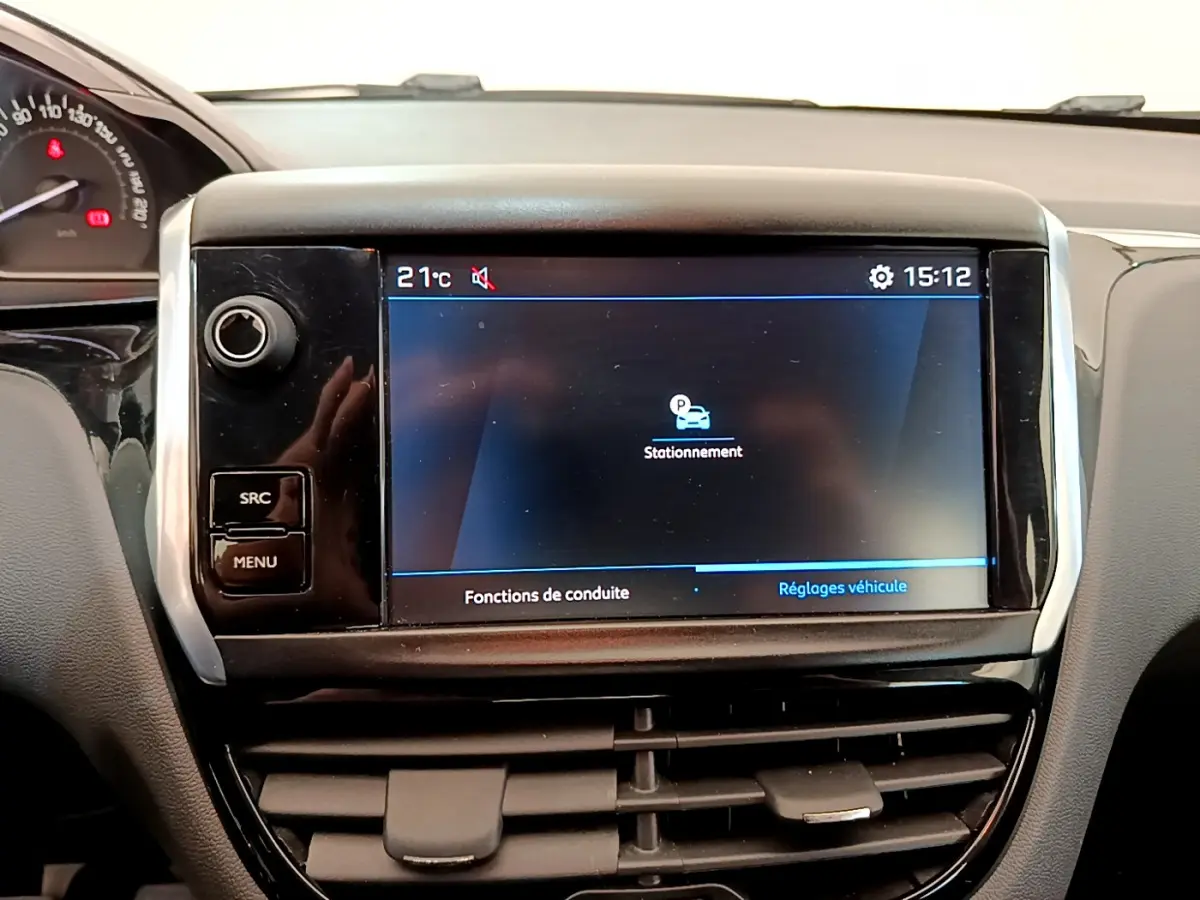 Écran tactile central affichant les réglages de stationnement dans l'habitacle d'une Peugeot 208 blanche Puretech 82 Signature.