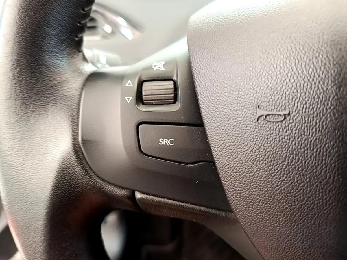 Gros plan sur les commandes gauche du volant cuir noir de la Peugeot 208 Puretech 82 Signature 2019.