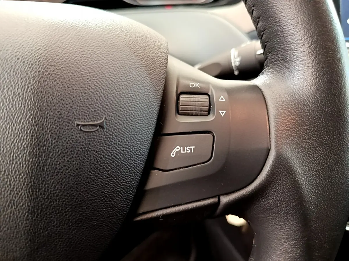 Gros plan sur les commandes du volant cuir noir de la Peugeot 208 Puretech 82 Signature 2019.