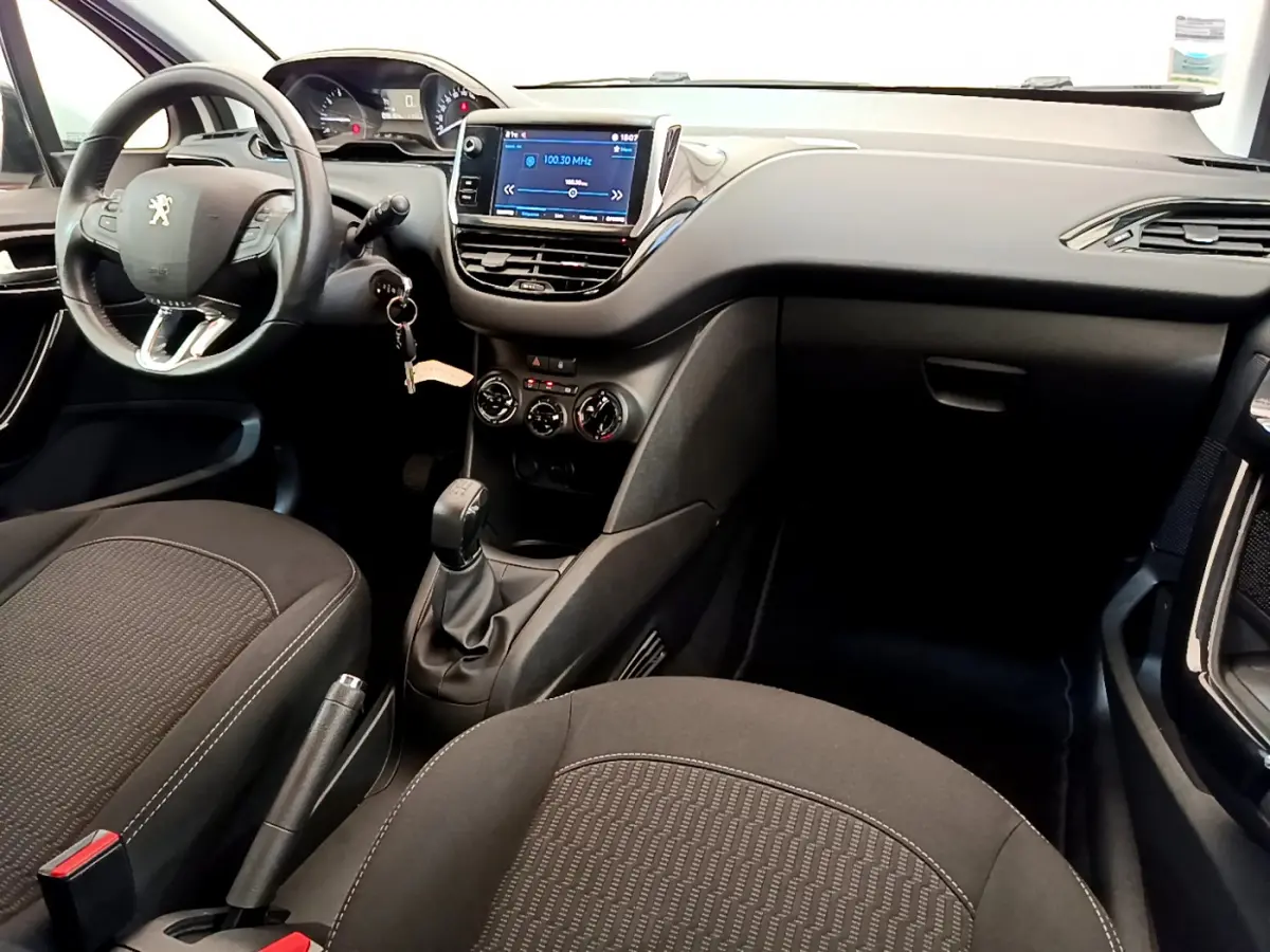 Intérieur avant de la Peugeot 208 Puretech 82 Signature 2019, montrant le tableau de bord et écran tactile central.