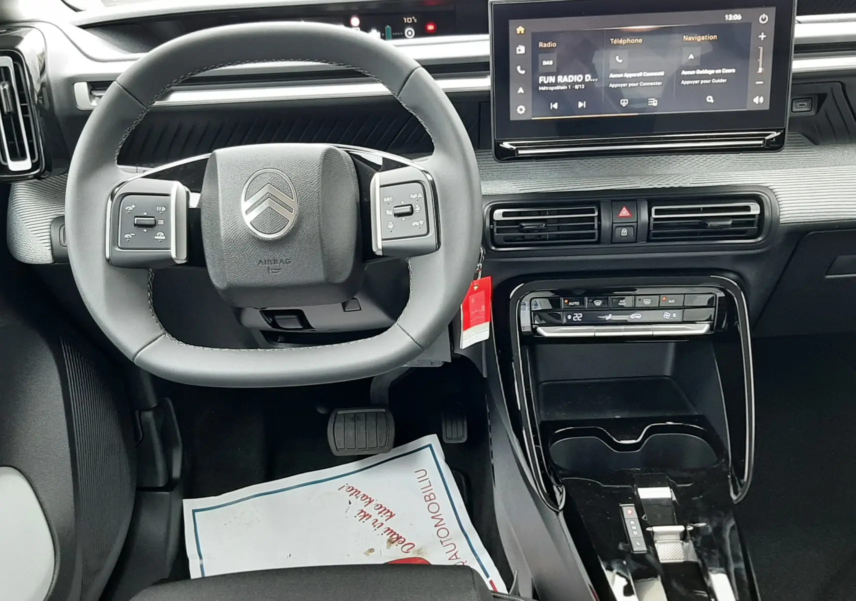 Vue intérieure avant centrée sur le volant et la console centrale du Citroën C3 Aircross hybride 2025, avec écran tactile et finition noire.