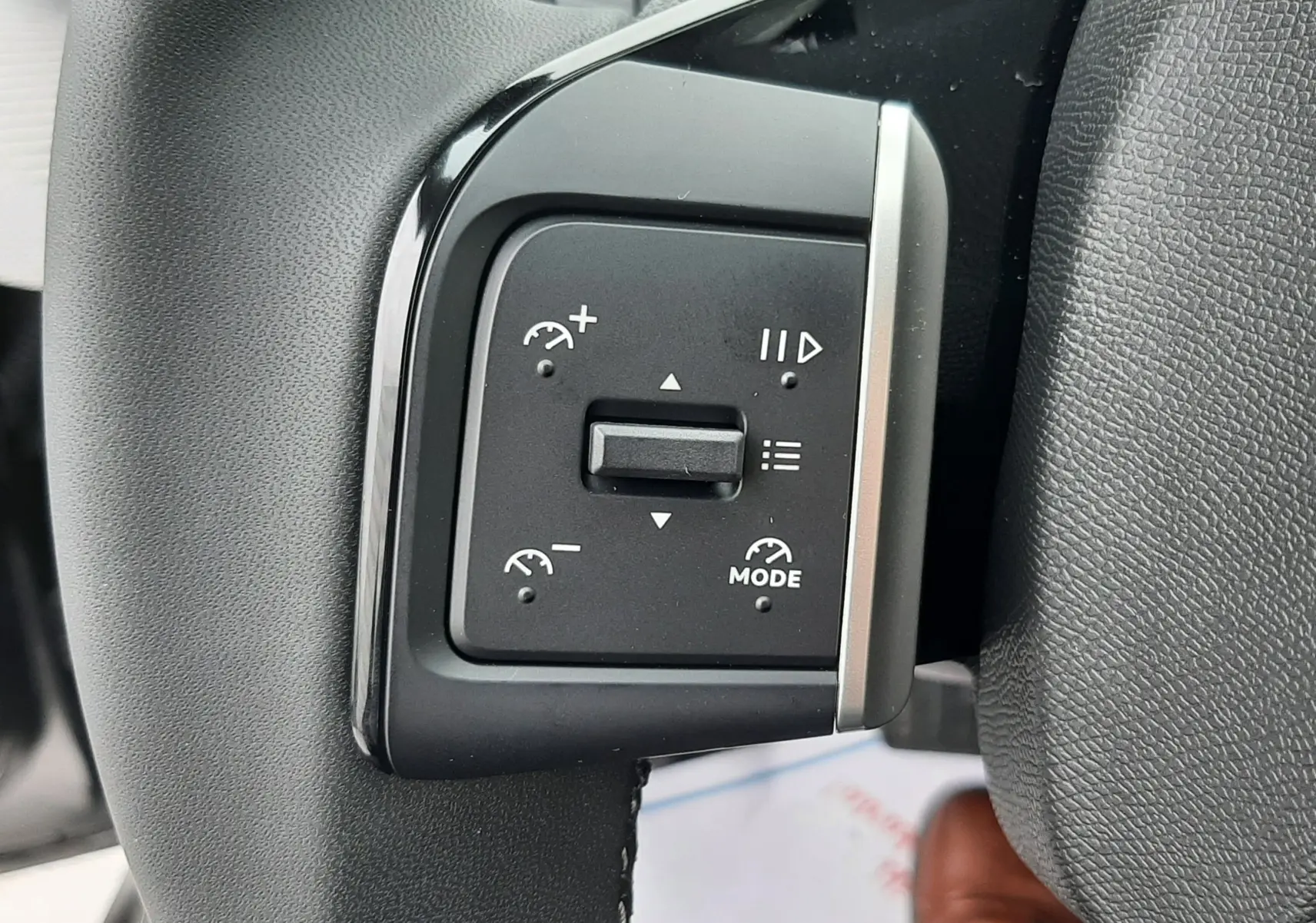 Gros plan sur les commandes de régulateur de vitesse au volant d'une Citroën C3 Aircross hybride gris toit noir, intérieur noir.