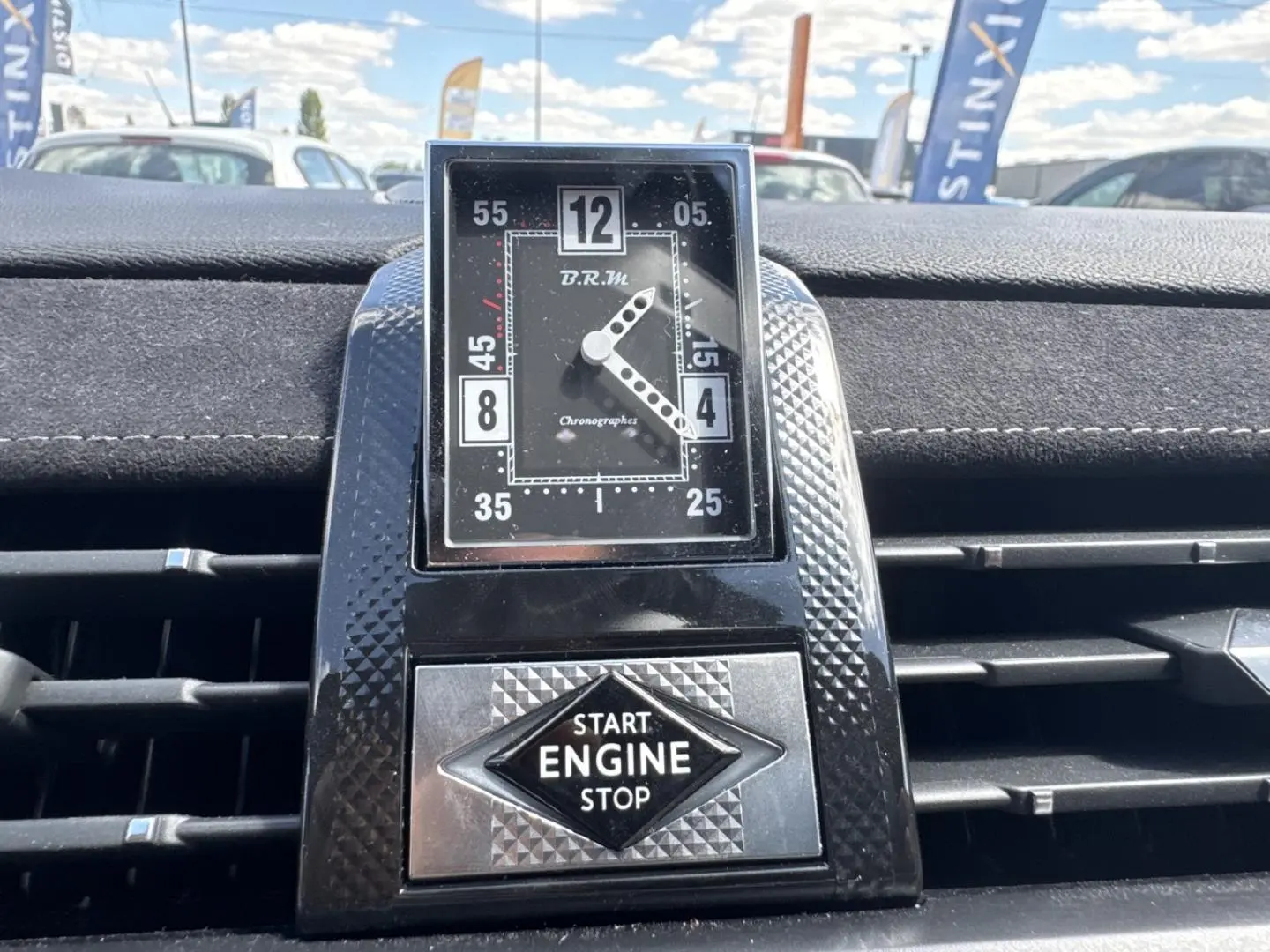 Gros plan sur l'horloge BRM et le bouton Start Engine Stop, tableau de bord en Alcantara noir du DS7 Vol de Nuit.