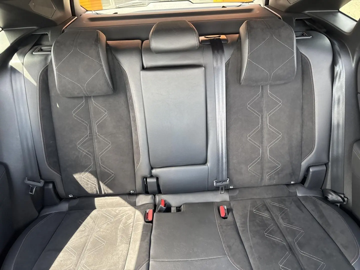 Vue de face des sièges arrière en Alcantara noir profond du DS7 1.5 BlueHDi 130ch Pallas, avec accoudoir central rabattable.