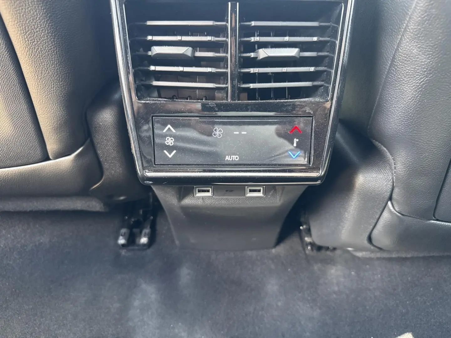 Vue rapprochée de la console arrière noire avec bouches d’aération et commandes climatisation du DS7 Vol de Nuit.