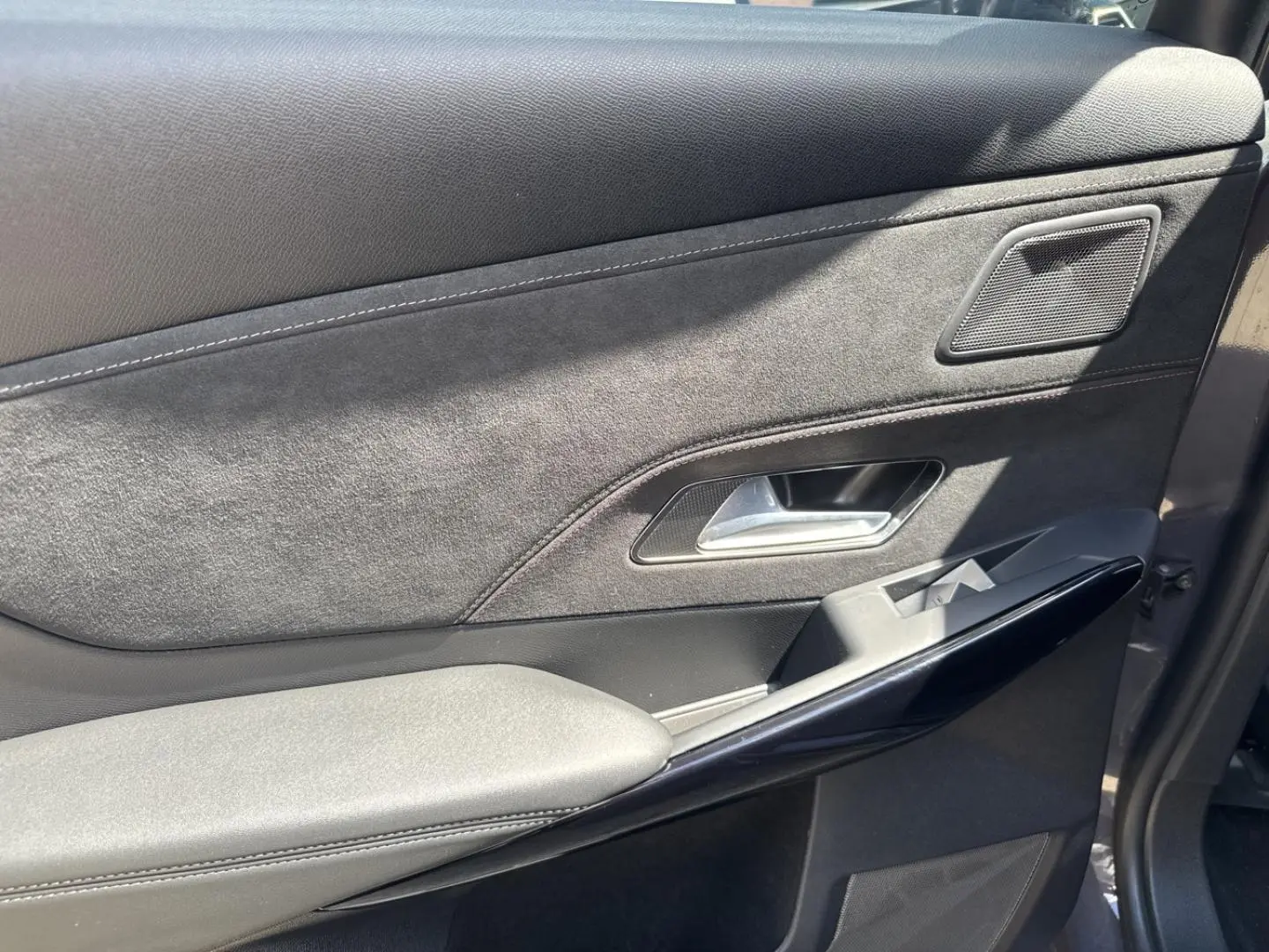Gros plan sur la porte avant droite du DS7 2025 Vol de Nuit, avec habillage Alcantara noir et insert brillant noir.