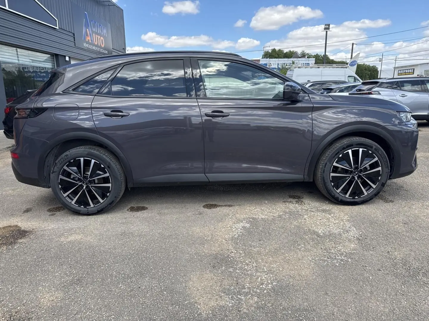 Profil côté gauche du SUV DS7 2025 en gris Vol de Nuit, avec jantes alliage noires et vitres surteintées.