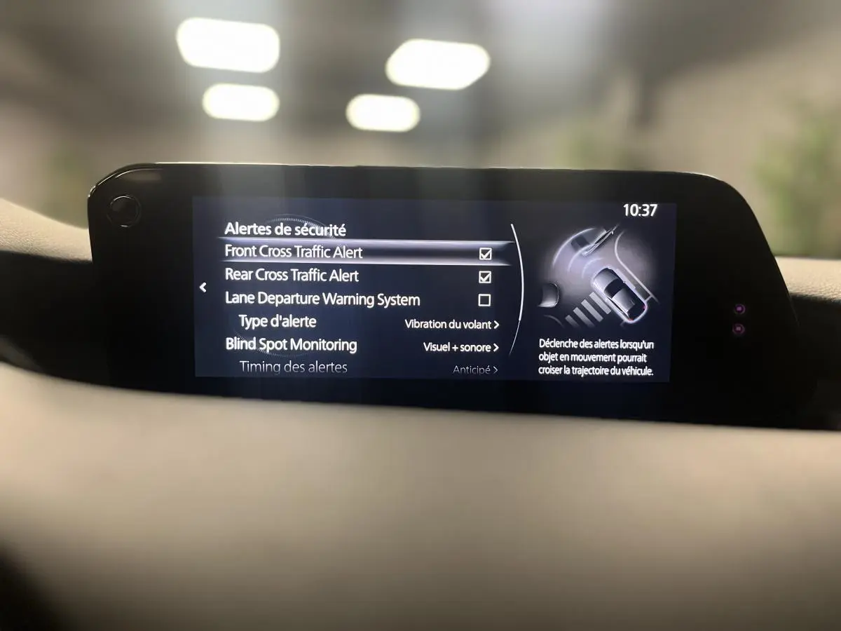 Écran central de la Mazda3 2023 affichant les alertes de sécurité avec interface moderne et lisible.