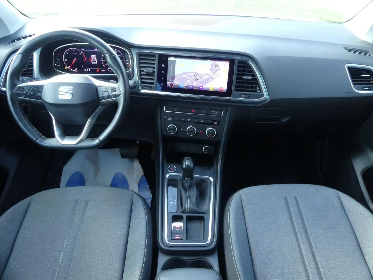 Vue intérieure avant du SEAT Ateca 2023 gris clair, avec tableau de bord numérique et écran tactile central.