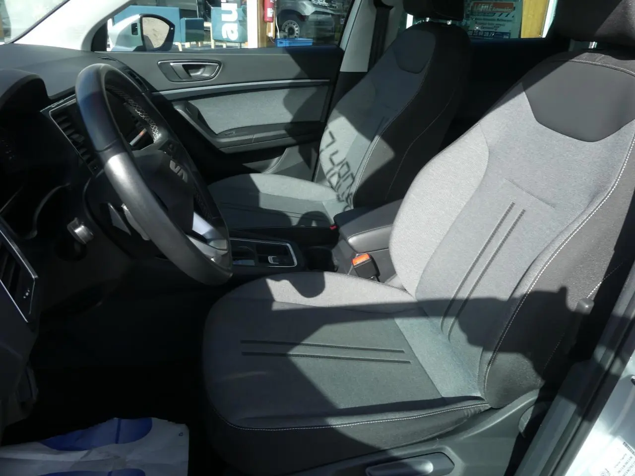 Intérieur avant droit du SEAT Ateca 2023 avec sièges textile gris clair et volant cuir multifonctions.