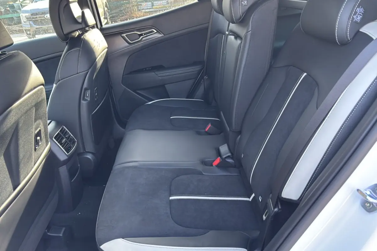 Vue intérieure côté droit sur la banquette arrière noire et grise du Kia Sportage 2026 blanc nacré toit noir.