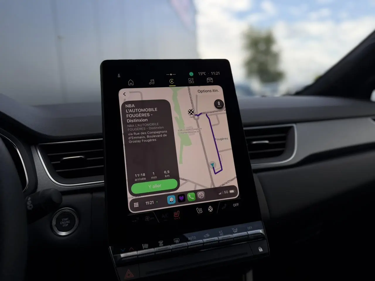 Vue intérieure centrée sur l'écran tactile vertical du tableau de bord du Renault Captur 2026, affichant la navigation.