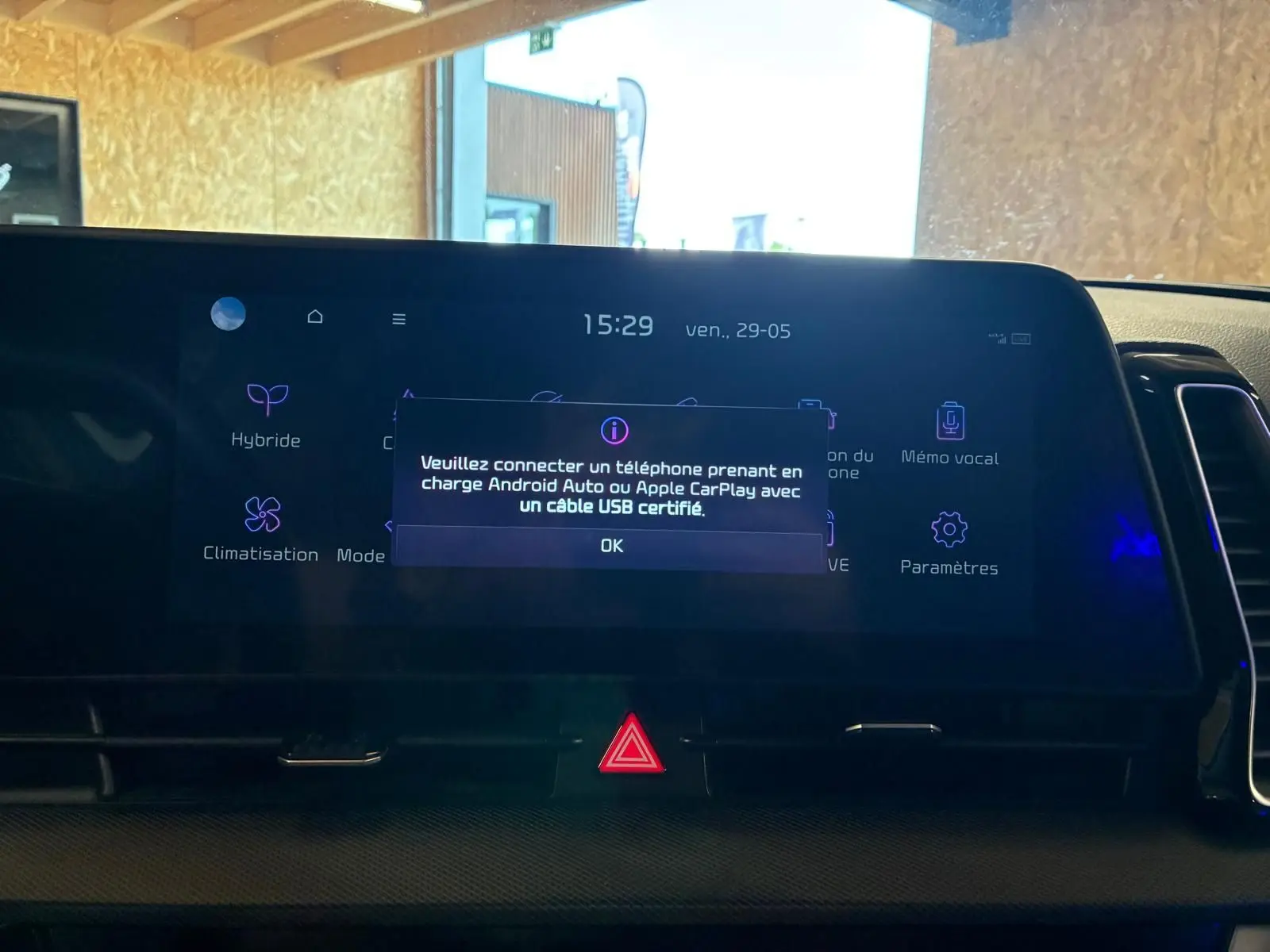 Vue rapprochée de l’écran tactile du tableau de bord du Kia Sportage gris 2024, affichant un message de connexion USB.