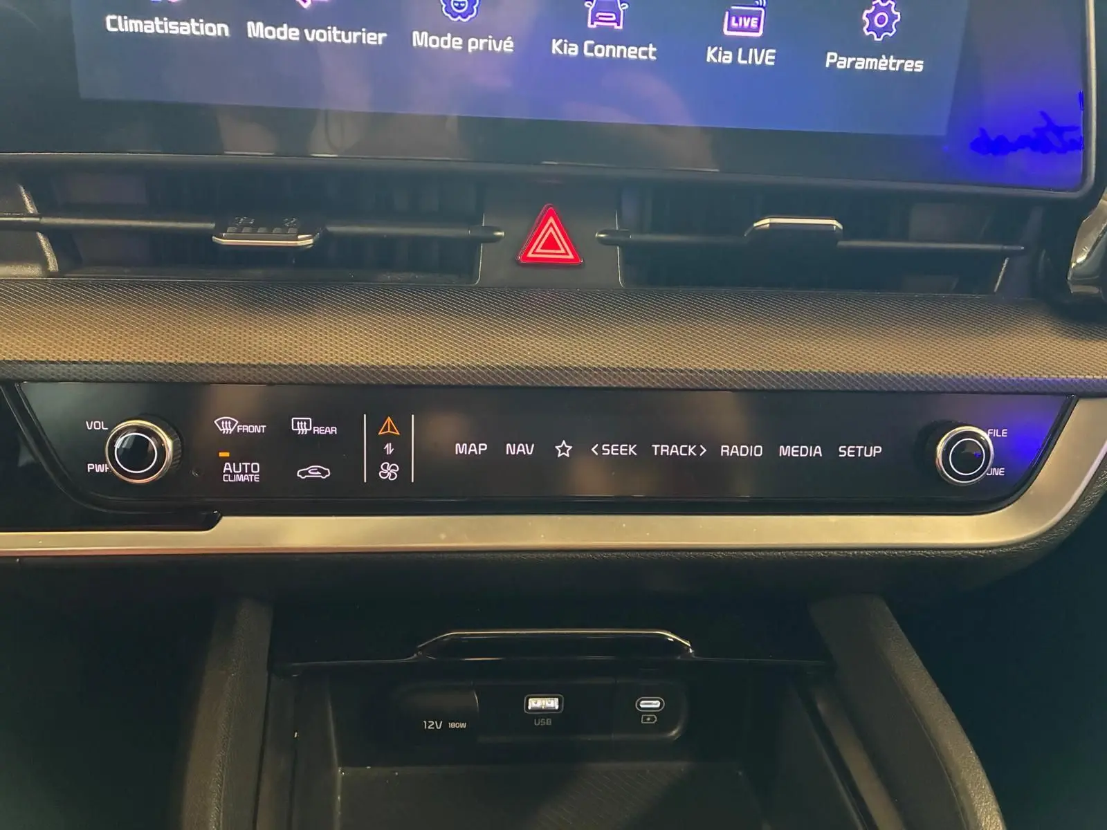 Vue rapprochée de la console centrale du Kia Sportage gris 2024, affichant les commandes multimédia et climatisation.