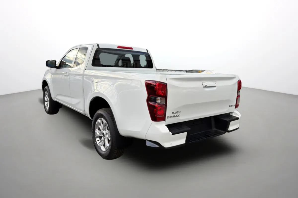 Vue 3/4 arrière droite d'un pick-up Isuzu D-MAX blanc Splash avec benne ouverte et jantes alu.