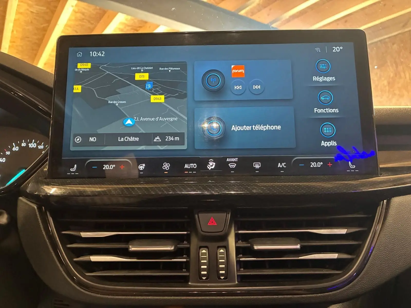 Vue rapprochée de l'écran tactile central et des commandes de climatisation d'une Ford Focus bleue 2024.