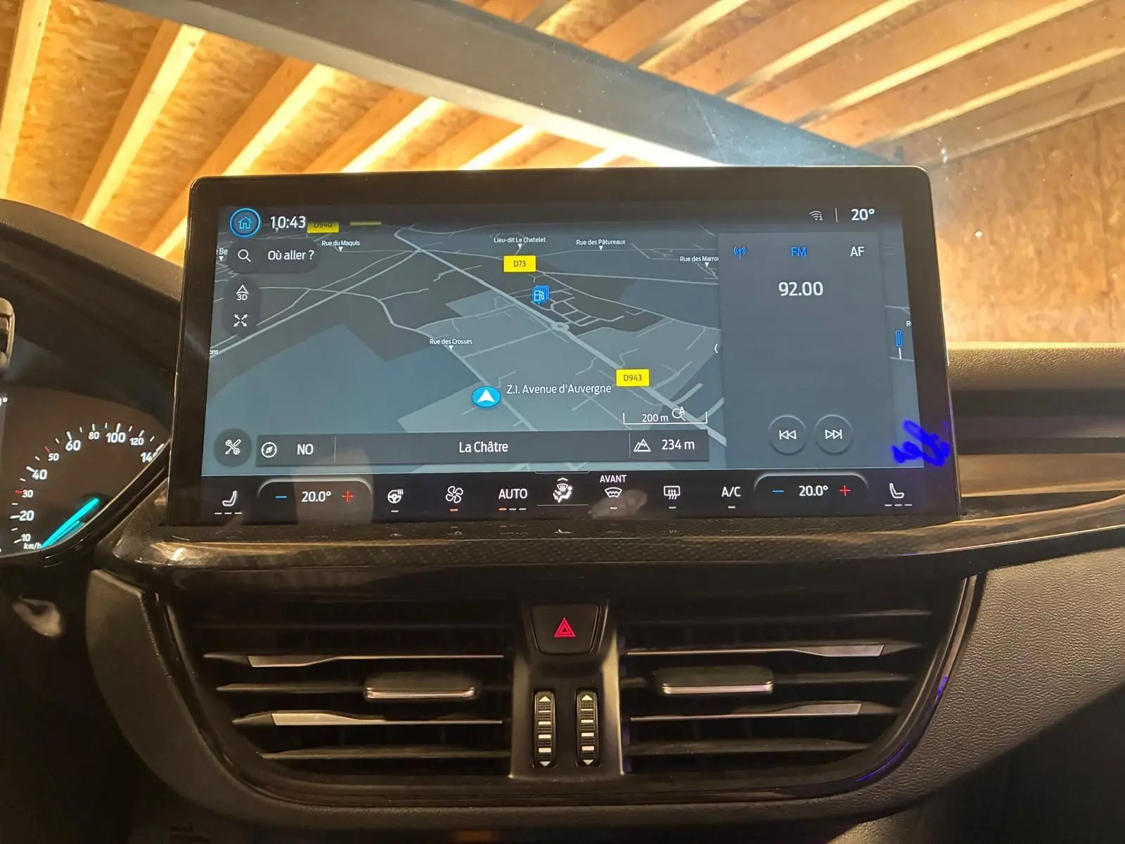 Écran tactile central avec navigation et commandes climatisation dans l’habitacle noir d’une Ford Focus bleue 2024.