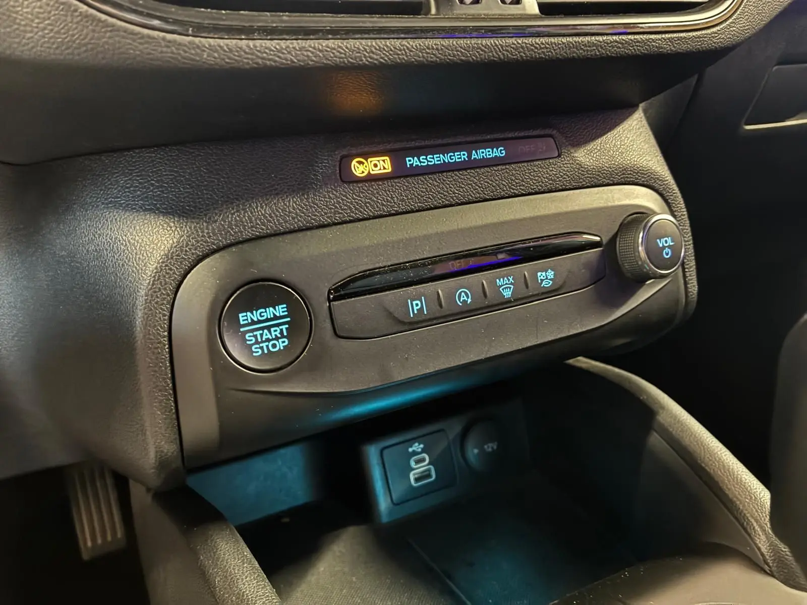 Détail du tableau de bord noir de la Ford Focus 2024 avec bouton start/stop et commandes climatisation visibles.