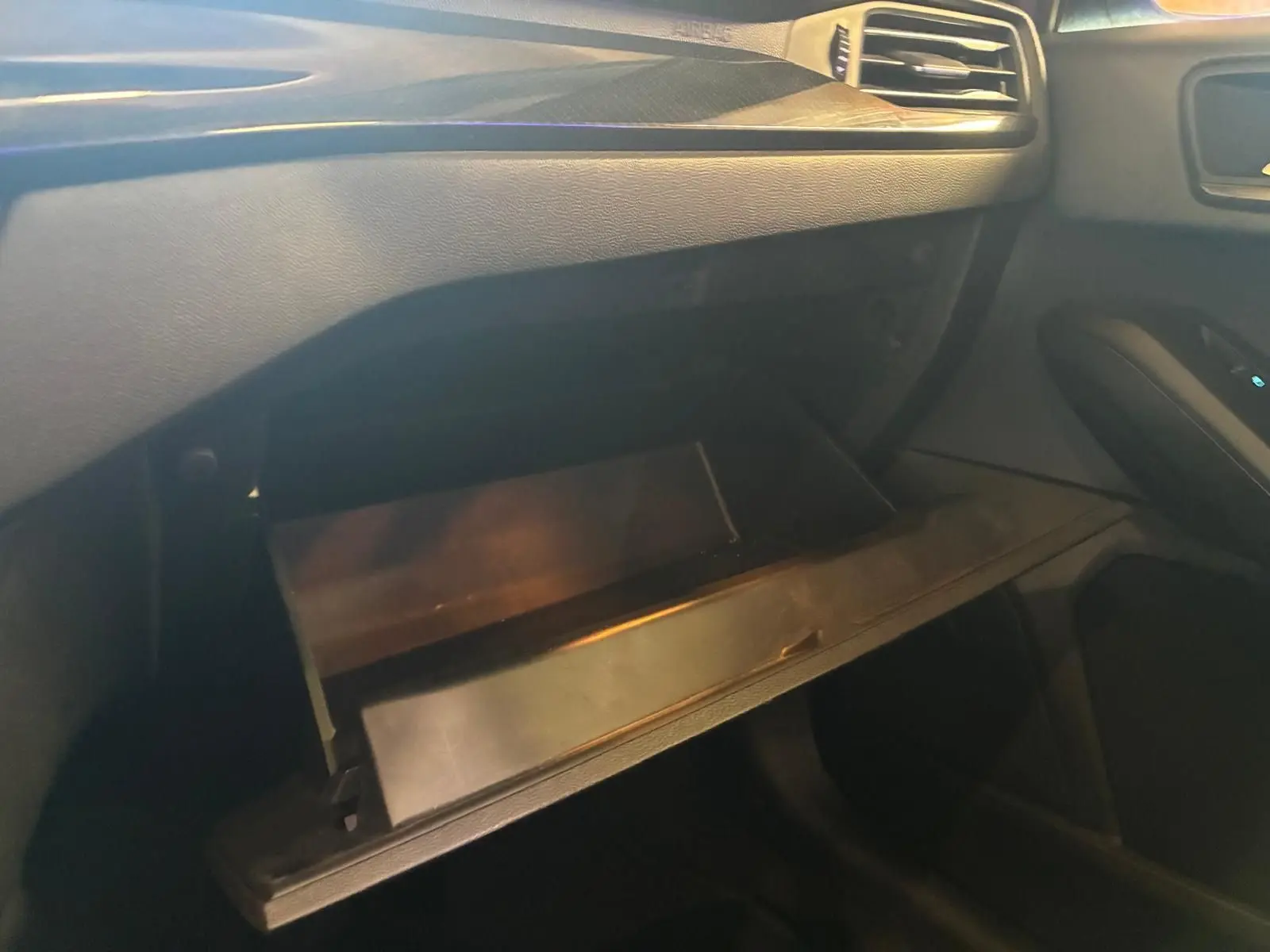 Vue intérieure côté passager de la boîte à gants ouverte dans une Ford Focus 2024 finition ST Line, intérieur noir.