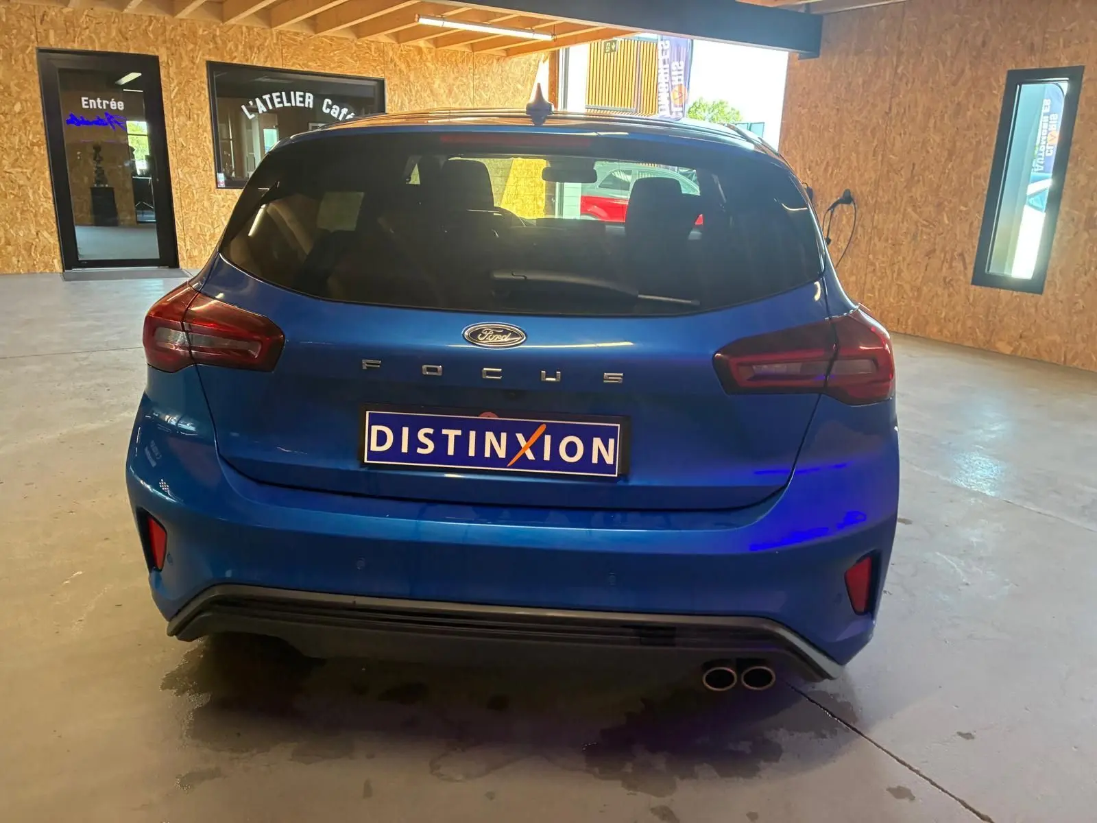 Vue arrière d'une Ford Focus bleue 2024, version ST Line avec double sortie d'échappement et vitres teintées.