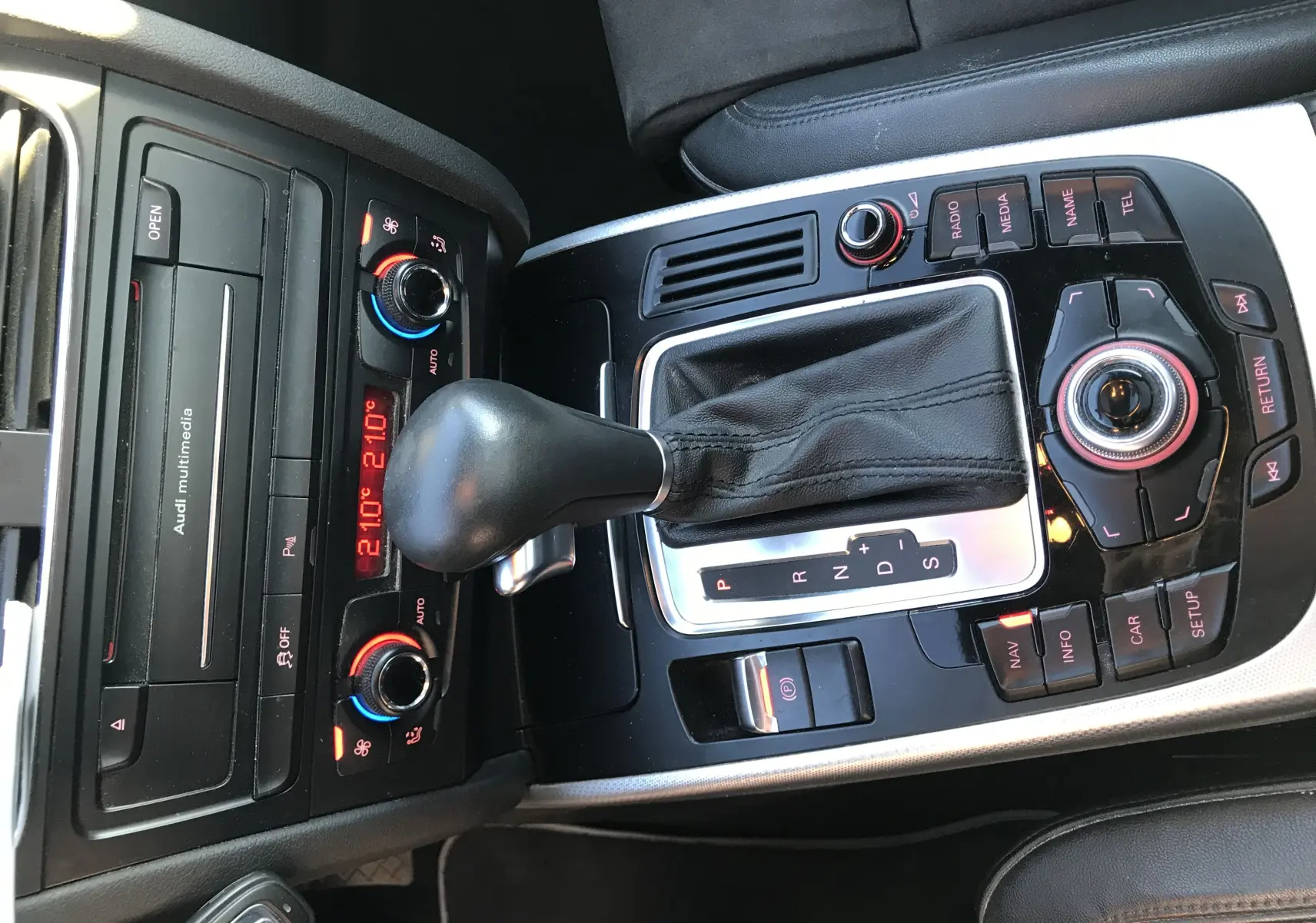 Vue rapprochée de la console centrale noire et argentée avec levier de vitesse automatique et commandes multimédia d'une Audi A5 gris dauphin.