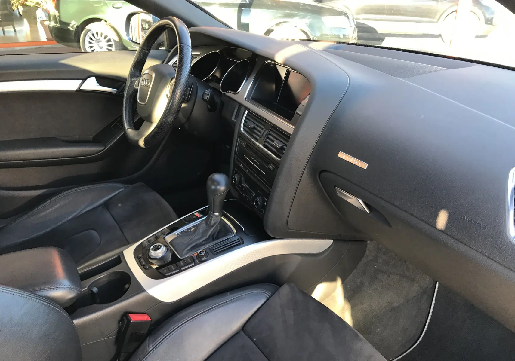 Intérieur noir de l'Audi A5 2012, vue côté conducteur sur le tableau de bord et la console centrale avec boîte auto.