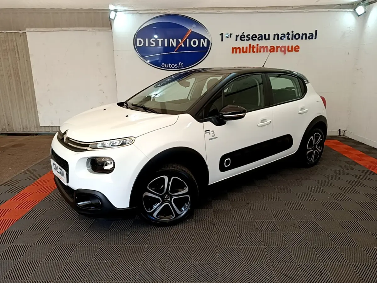 Citroën C3 blanc vue 3/4 avant droit avec toit noir et protections latérales noires en concession.