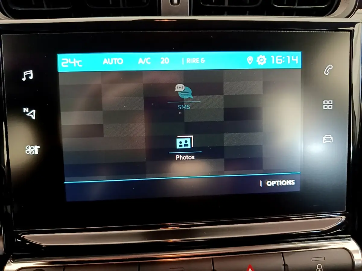 Écran tactile central de la Citroën C3 PureTech 82 blanc, affichant les options SMS et photos à 16h14.
