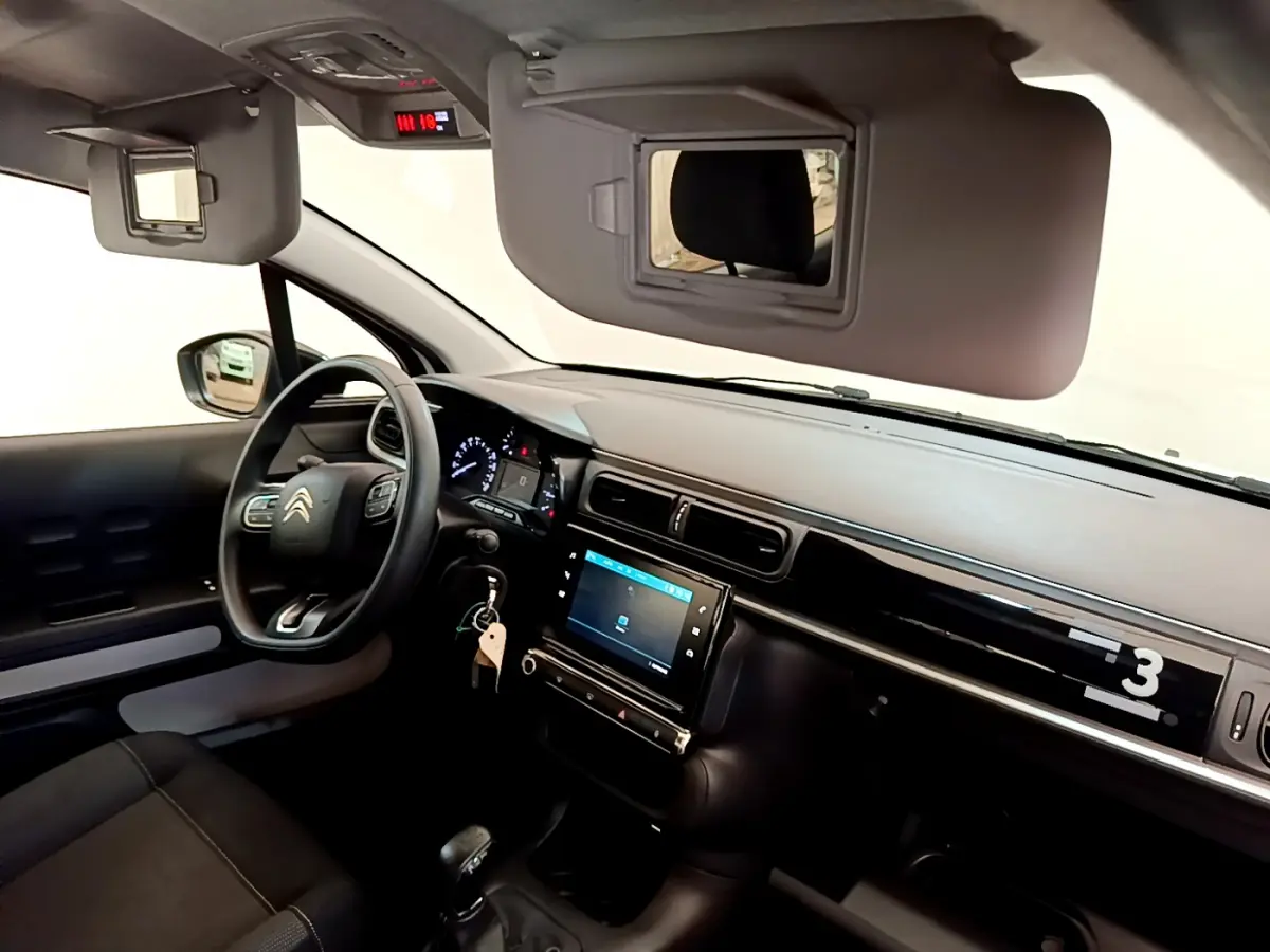 Intérieur de la Citroën C3 PureTech 82, vue côté conducteur sur tableau de bord et écran tactile central.