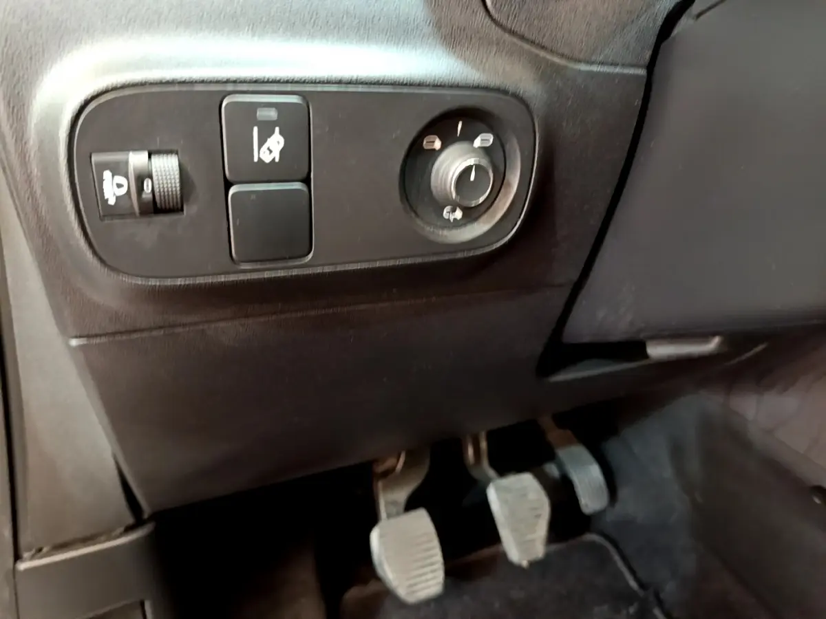 Vue intérieure côté gauche montrant les commandes des rétroviseurs et les pédales d'une Citroën C3 blanche PureTech 2019.