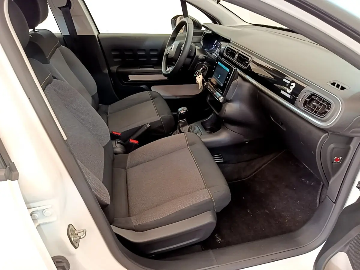 Vue intérieure côté conducteur de la Citroën C3 blanche 2019 avec tableau de bord tactile et sièges gris.