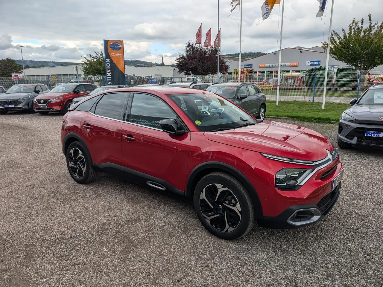 Citroën C4 2024 rouge foncé vue 3/4 avant droit avec jantes alliage et rétroviseurs noirs brillants.