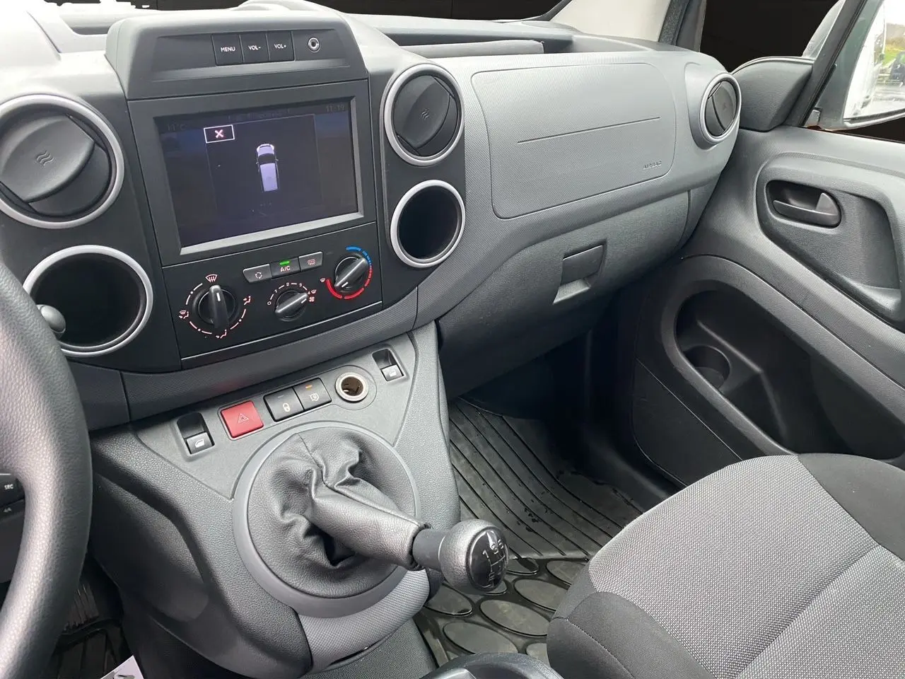 Vue intérieure côté passager du tableau de bord et levier de vitesse manuel d'un Citroën Berlingo blanc de 2018.