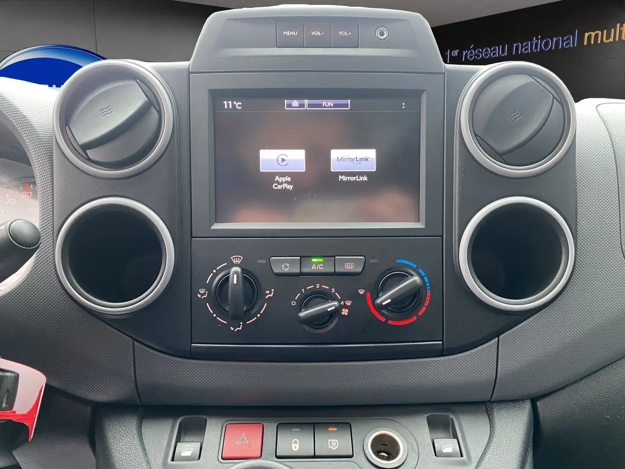 Vue rapprochée du tableau de bord du Citroën Berlingo blanc 2018, avec écran tactile et commandes de climatisation.