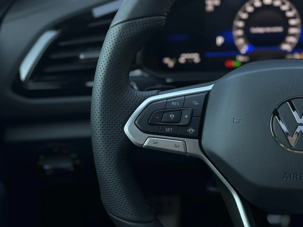 Gros plan sur le volant multifonction en cuir noir avec logo Volkswagen du Volkswagen T-Roc 2.0 TDI R-Line 2025.