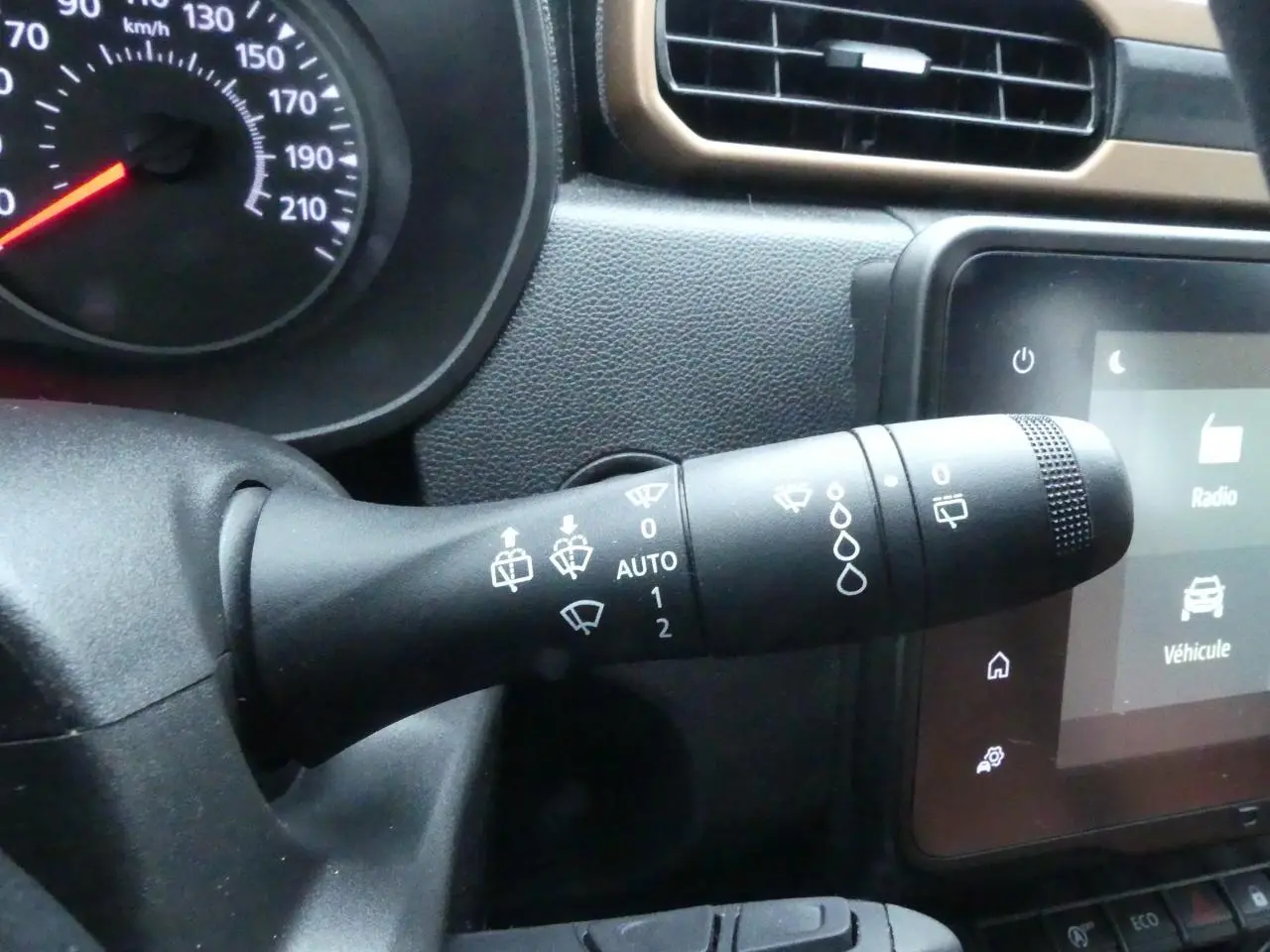 Gros plan sur la commande d'essuie-glace du tableau de bord noir du Dacia Duster 2023 version Extreme.