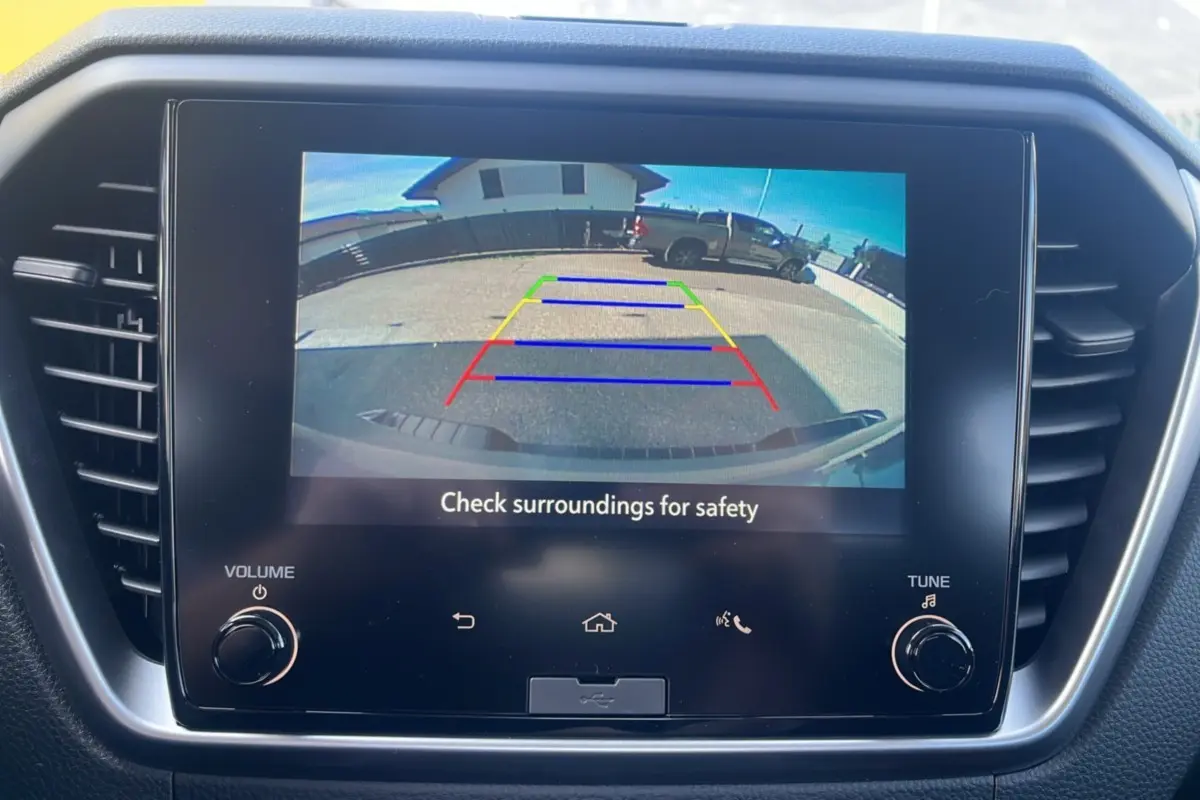 Écran tactile intérieur affichant la caméra de recul du pick-up Isuzu D-MAX gris Kinabalu en stationnement arrière.