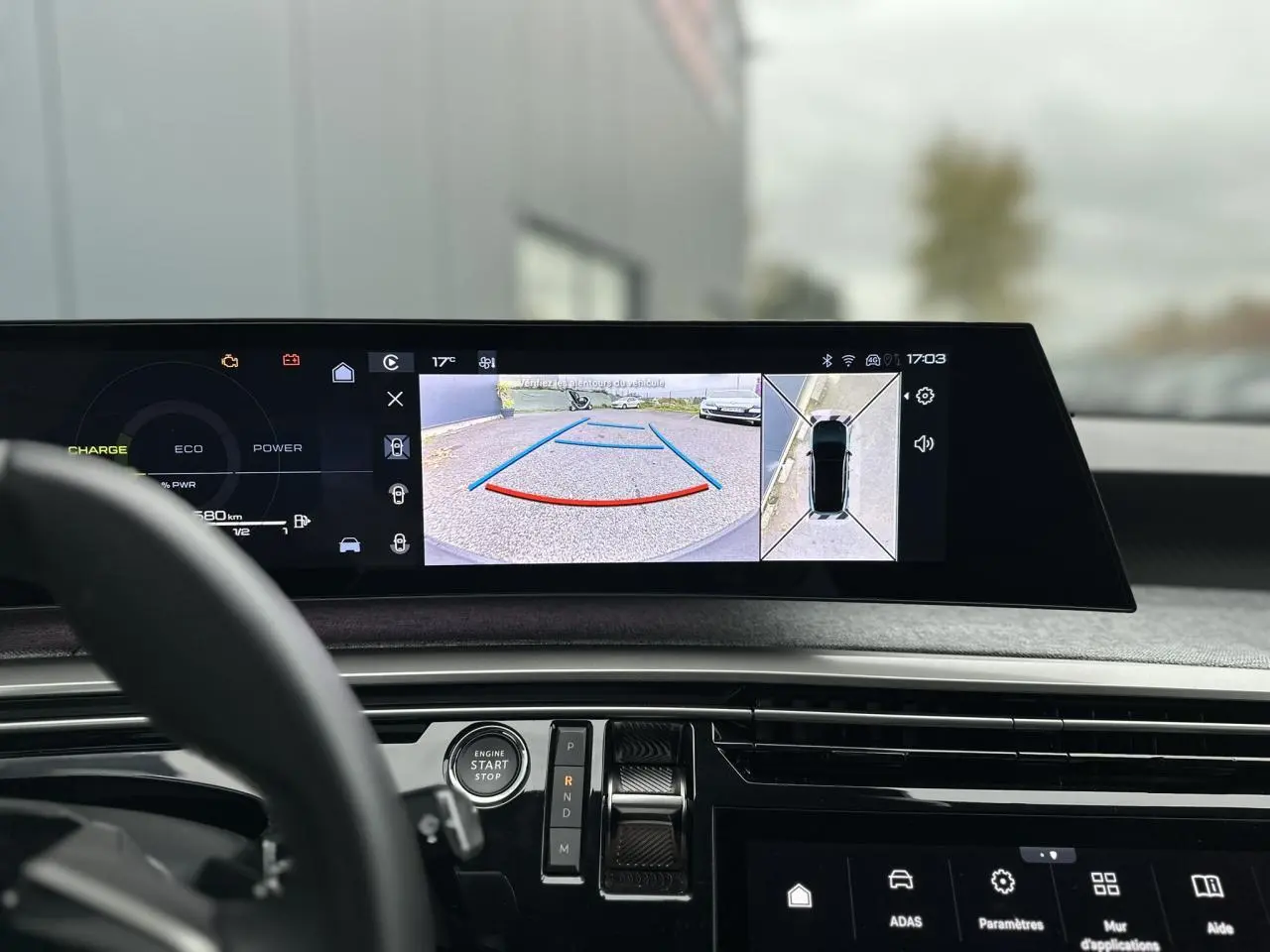 Vue intérieure du tableau de bord du Peugeot 3008 Hybrid 2024 avec écran affichant la caméra 360° en marche arrière.