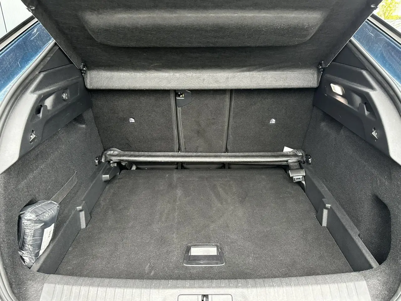 Coffre ouvert du Peugeot 3008 Hybrid 145 bleu Obsession, vue intérieure arrière montrant l'espace de chargement.