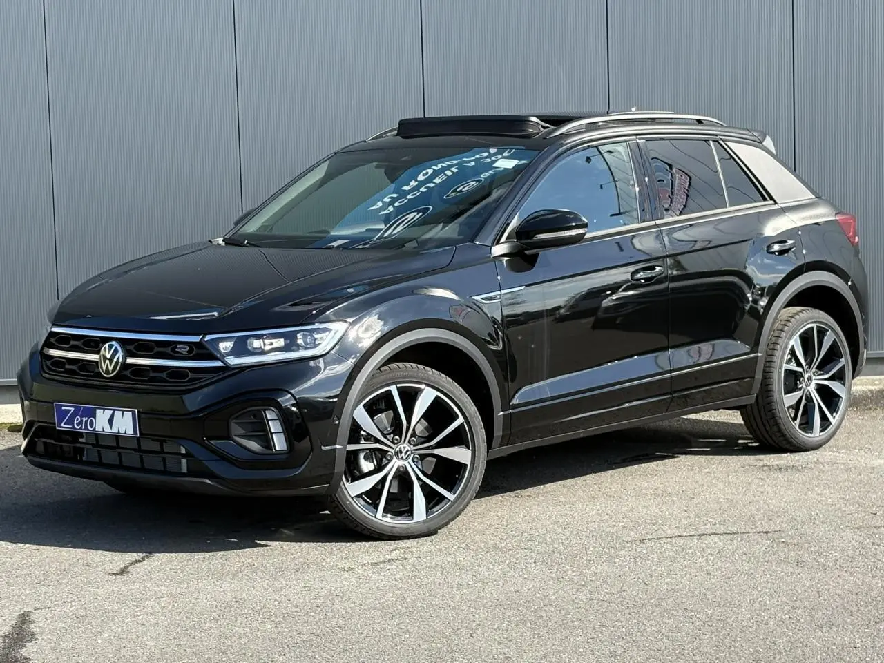 Volkswagen T-Roc noir Grenadilla en 3/4 avant droit avec jantes alliage 19" Misano et toit ouvrant ouvert.