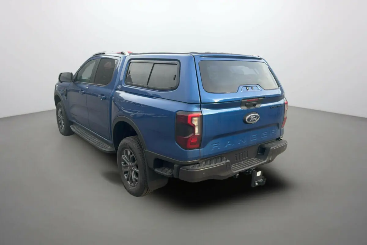 Ford Ranger 3.0 V6 Wildtrak bleu lightning vu de l'arrière droit avec hard-top vitré et attelage.