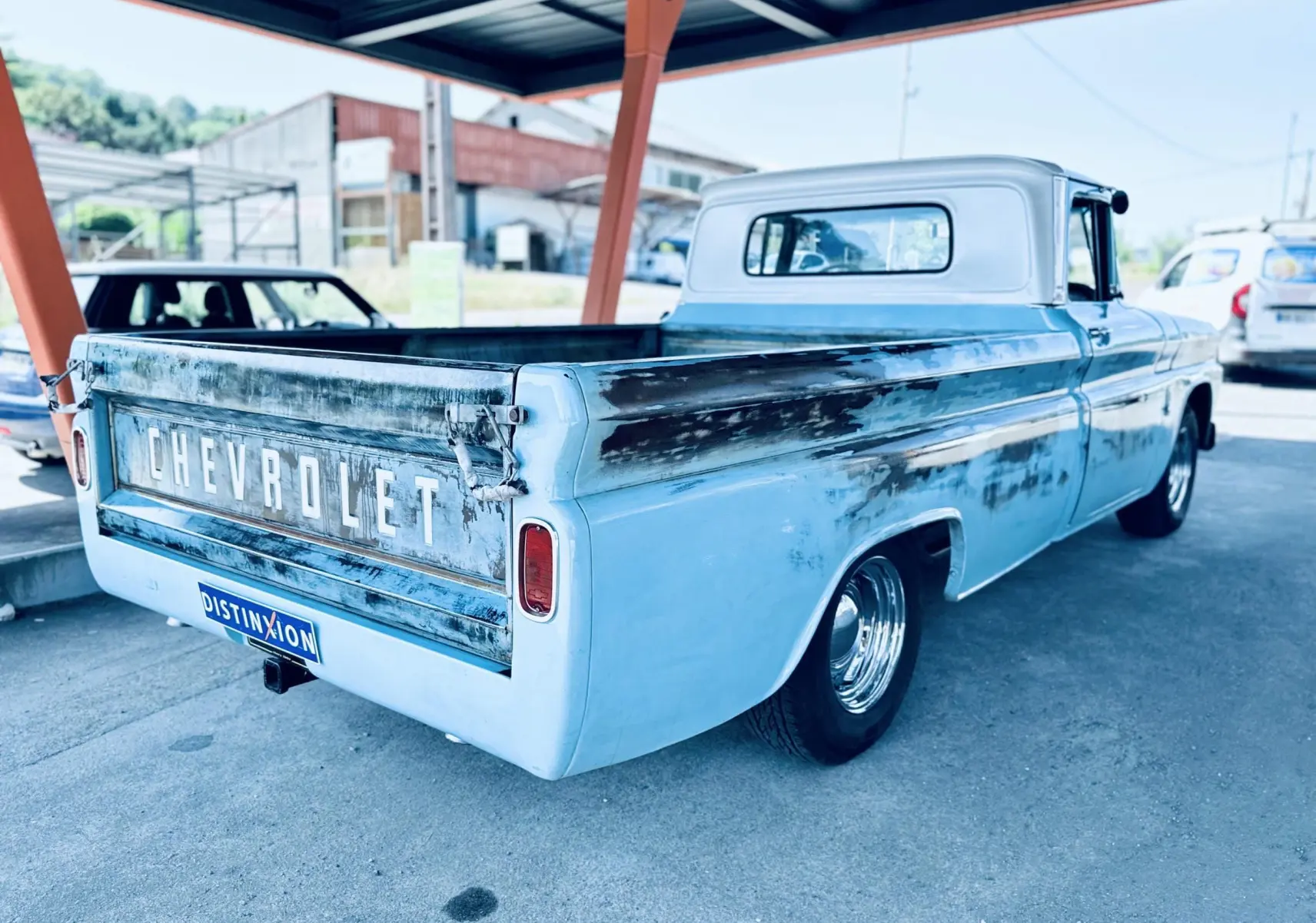 Vue 3/4 arrière droite d’un Chevrolet C10 Apache 1963 bleu avec peinture patinée et plateau ouvert.