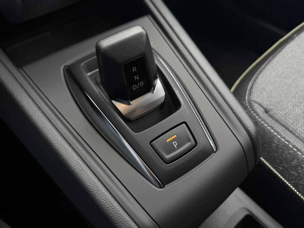 Gros plan sur la commande de boîte automatique noire du Renault Captur 2026, avec bouton de stationnement orange.
