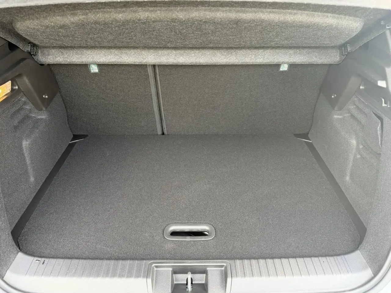 Coffre ouvert du Renault Captur gris Rafale, vue intérieure montrant le plancher de coffre plat et le cache-bagages.