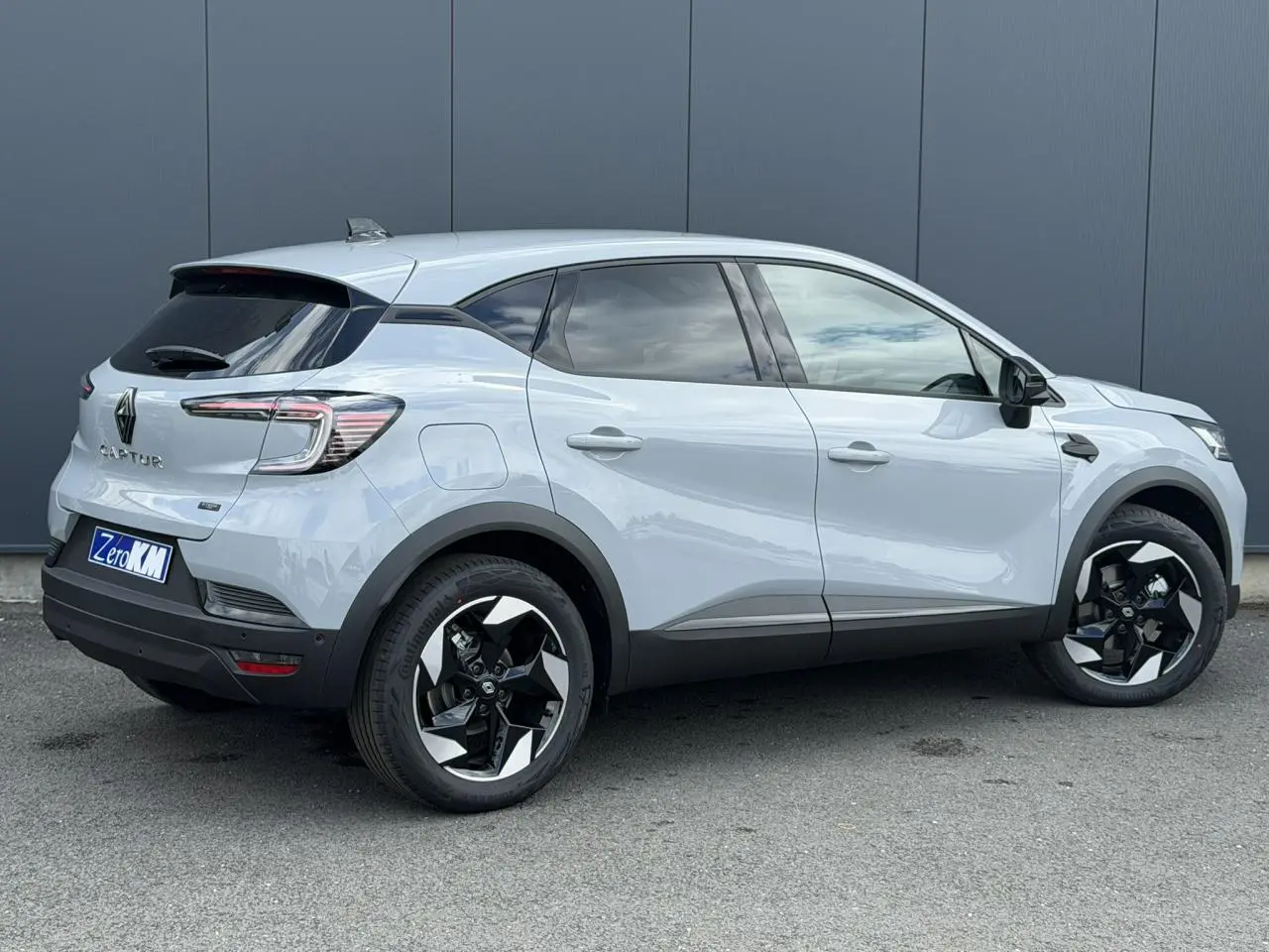 Vue de profil droit du Renault Captur gris Rafale 2026 avec jantes noires et détails noirs sur les rétroviseurs et bas de caisse.