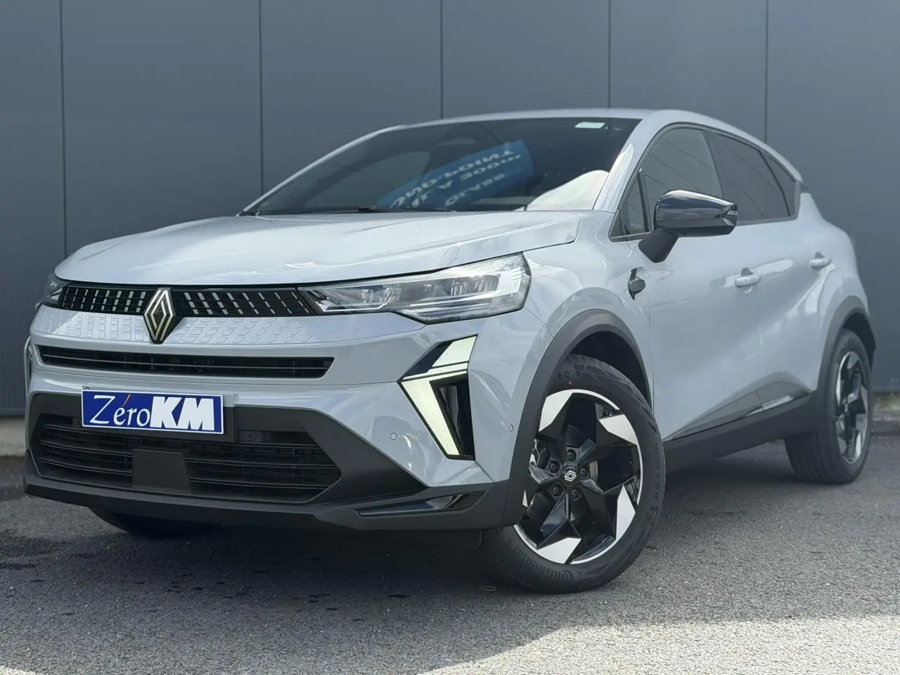 Renault Captur 2026 gris Rafale en 3/4 avant droit, avec jantes aluminium noires et phares LED distinctifs.