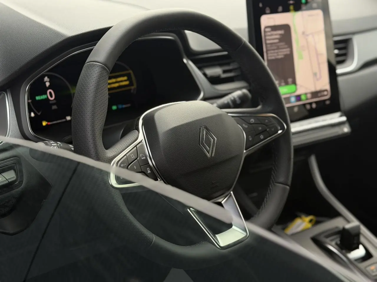 Vue rapprochée du volant noir en textile refined du Renault Captur 2026 avec tableau de bord numérique et écran tactile.